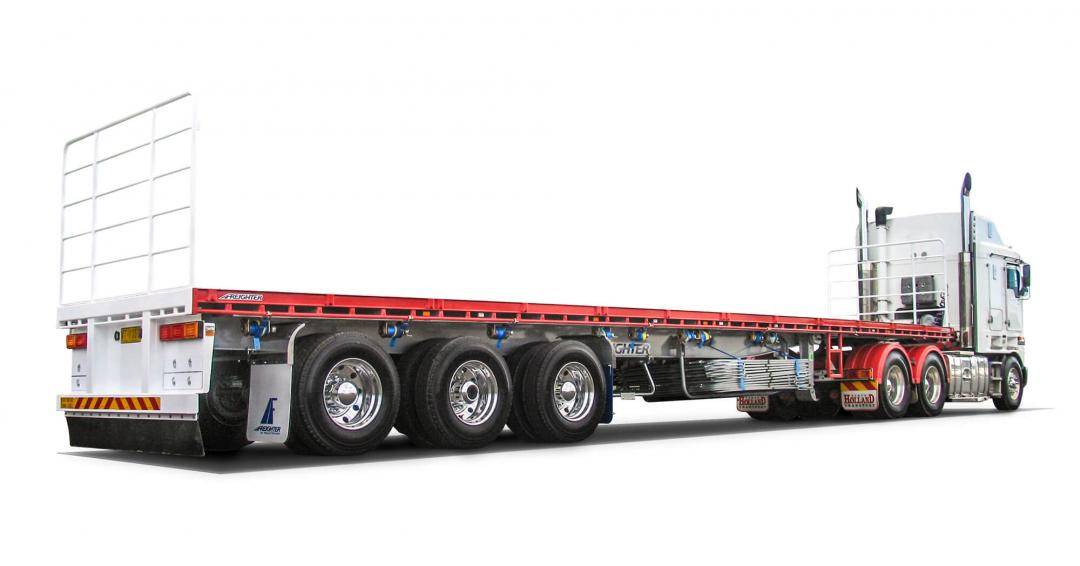 Freighter semi-trailer flat top trailer on a truck driving on a white background