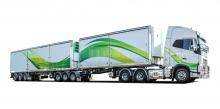 Green and White Freighter Slide a Side Refrigerated Lead trailer on truck driving on a white background